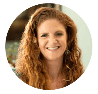 Dr. Stephanie Kinsey - Palencia Dental Dr. Stephanie Kinsey, with long curly red hair, smiling warmly in a professional setting – Palencia Dental