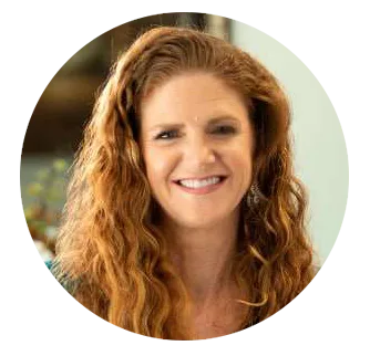 Dr. Stephanie Kinsey - Palencia Dental Dr. Stephanie Kinsey, with long curly red hair, smiling warmly in a professional setting – Palencia Dental