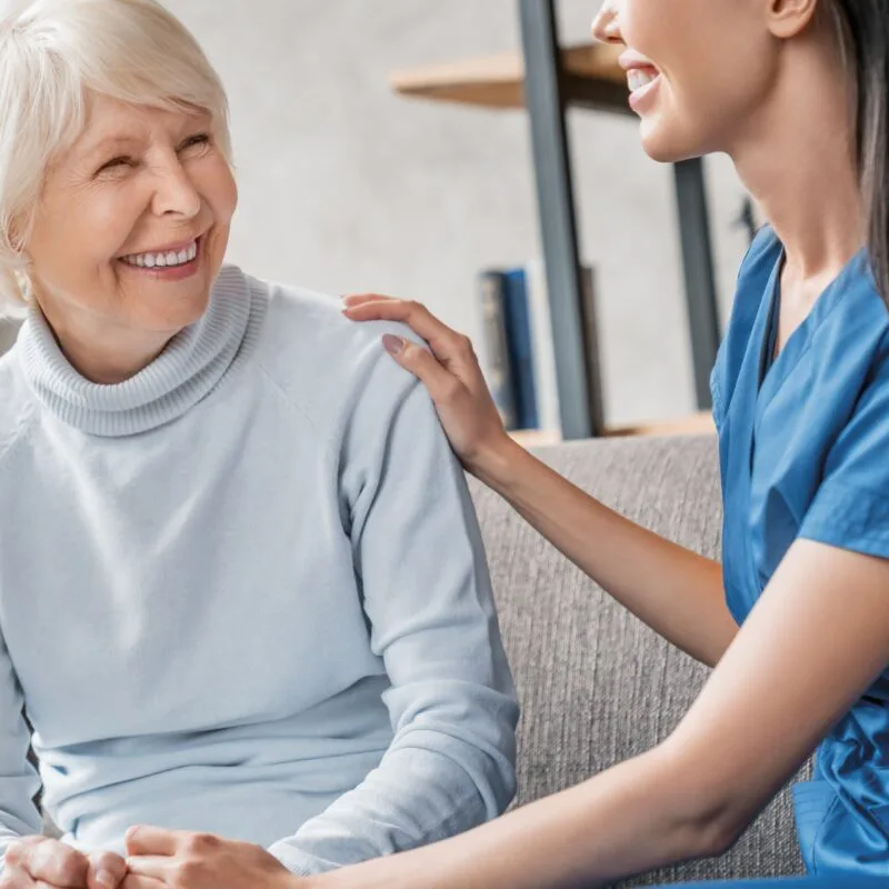 Smiling elderly woman engaging with a compassionate female dental professional, highlighting trust, comfort, and the patient-first philosophy at Palencia Denta